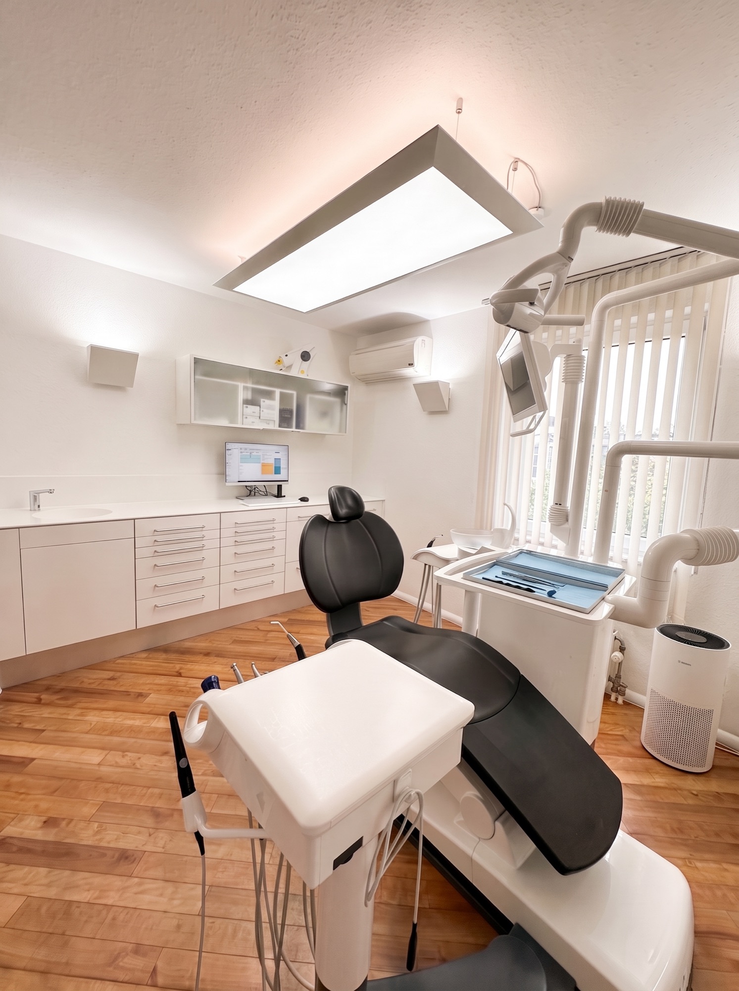 Behandlungszimmer der Praxis mit Arbeitsfläche und Luftreinigung